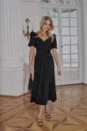 Hover - Black maxi dress with bouffant sleeves, straight top, flared bottom, buckled belt with detachable applique and pointed neckline
