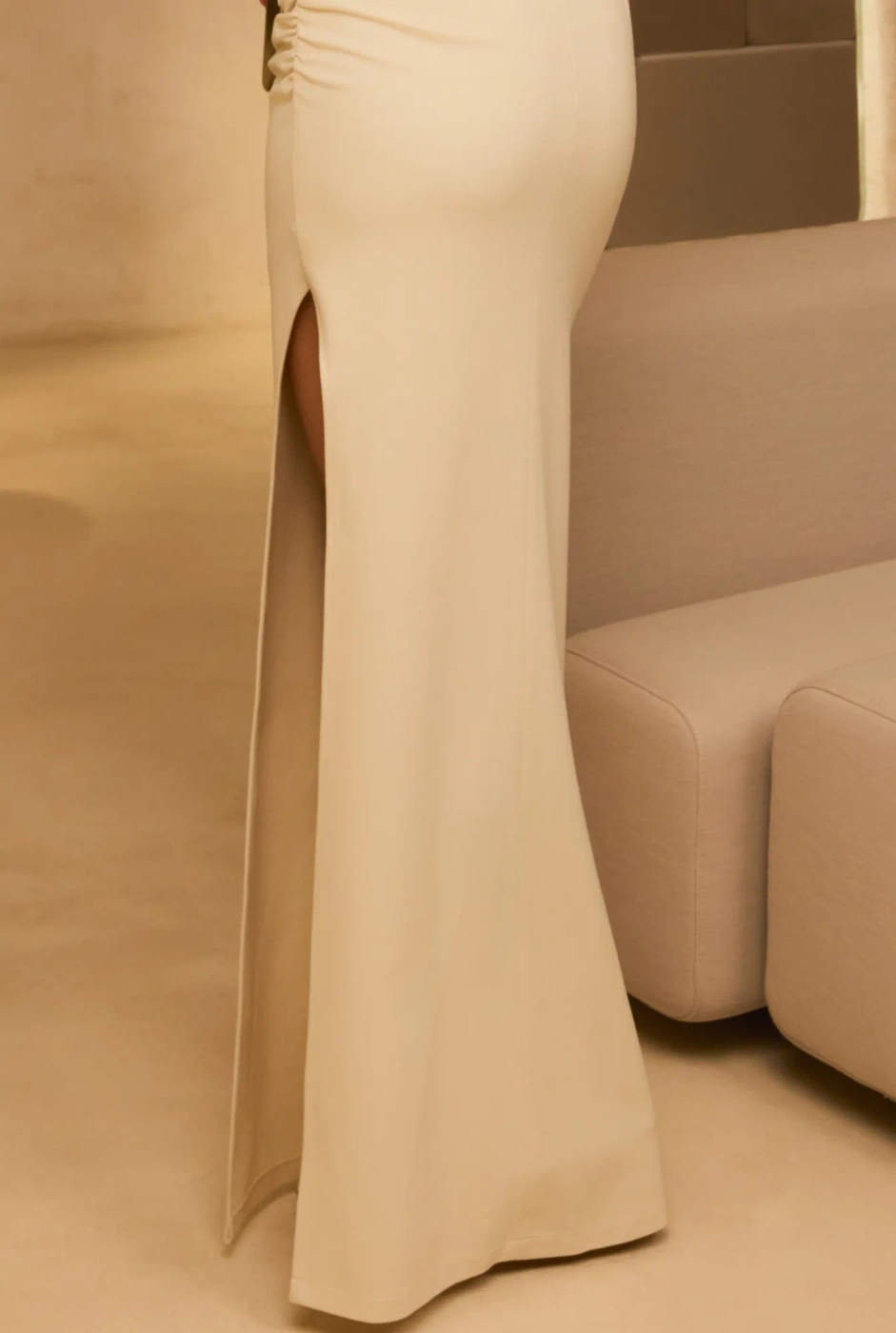 Elegante – asymmetrical maxi dress in ecru with a feather brooch