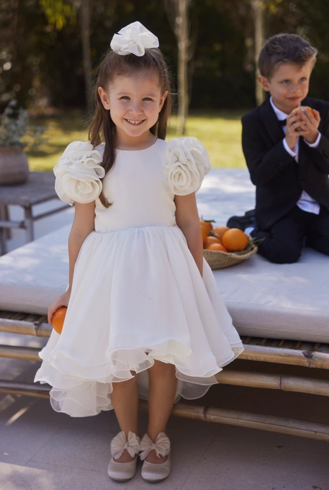 Ajla - Tailliertes Kinder-Knitterkleid mit Blumenapplikationen und asymmetrischem Unterteil