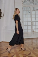 Hover - Black maxi dress with bouffant sleeves, straight top, flared bottom, buckled belt with detachable applique and pointed neckline