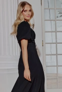 Hover - Black maxi dress with bouffant sleeves, straight top, flared bottom, buckled belt with detachable applique and pointed neckline