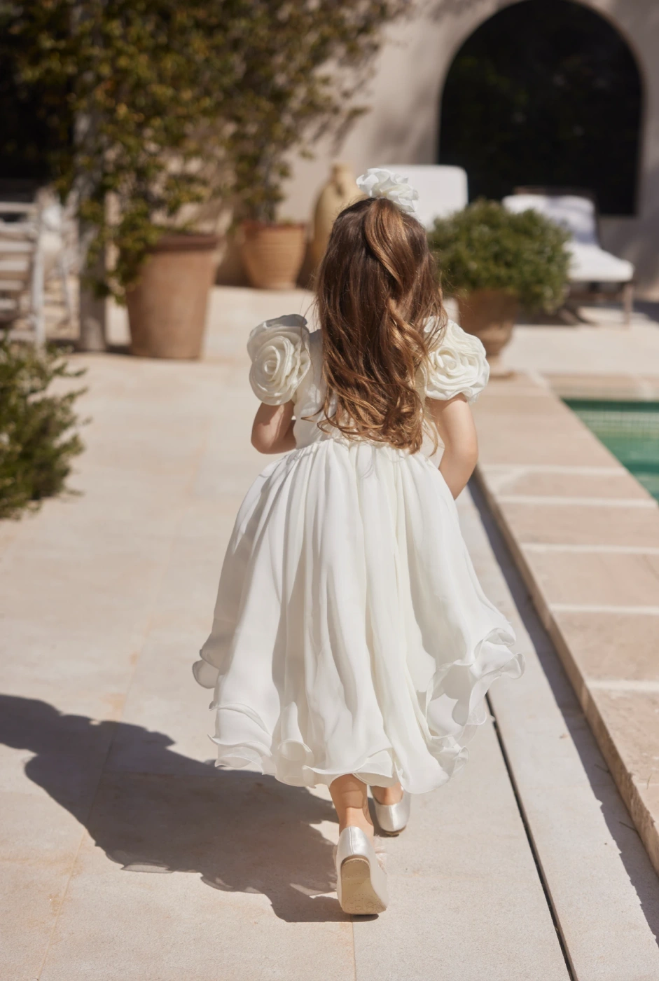 Ajla - Tailliertes Kinder-Knitterkleid mit Blumenapplikationen und asymmetrischem Unterteil